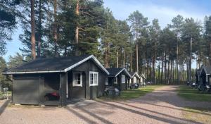 胡迪克斯瓦尔Hostel Hudiksvall Malnbaden Camping的停在森林中的一排小屋