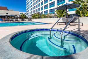 圣佩德罗洛杉矶港皇冠假日酒店的一个带遮阳伞和遮阳伞的小型游泳池