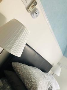 罗奇福德AC Hideout的一间卧室配有一张带台灯和枕头的床