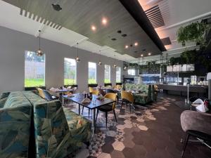 奥克兰JetPark Auckland Airport Hotel的用餐室设有桌椅和窗户。