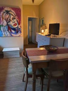 蒙得维的亚Apartamento independiente en alquiler En casa de familia的一间设有桌子和墙上绘画的用餐室