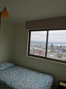比亚里卡Villarrica Mirador Apartment的一间卧室设有一张床和一个大窗户