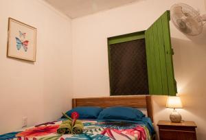 利蒙港Finca D'Elía Lodge的一间卧室配有一张带绿色百叶窗的床