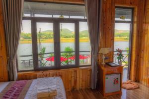 峰牙Phong Nha Escape Bungalow的卧室设有河景大窗户