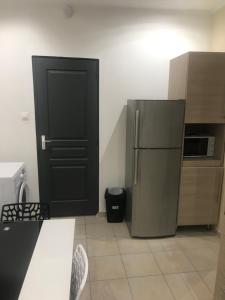 圣艾蒂安Sci ZLR的厨房设有黑色的门和冰箱。