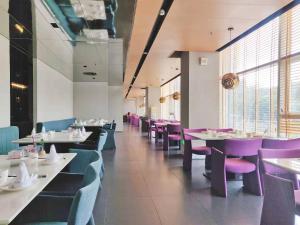 深圳深圳南山科技园HUA华酒店的一间设有白色桌子和紫色椅子的用餐室