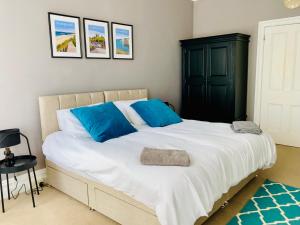 伯恩茅斯Lovely Westbourne apartment - 15 min walk to beach的卧室配有带蓝色枕头的大型白色床