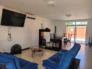 IztapaCasa en condominio monterrico的客厅配有蓝色椅子和电视