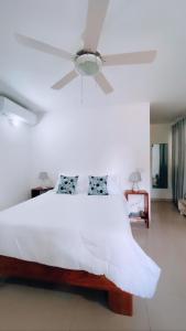 拉斯特拉纳斯Villa Brise de Mer的卧室配有白色的床和吊扇