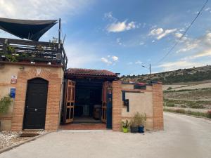 VellizaCasa Rural Alfoz, -Tiny house- con patio privado, barbacoa, wifi, netflix, Aire acondicionado的街上有一扇黑色门的砖房