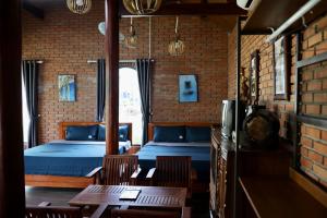 波来古市Homestay Hơ Đơng的一间设有两张床和一张桌子及椅子的房间