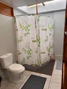 莫雷阿Moorea Vaiare Lodge的浴室设有卫生间和植物淋浴帘