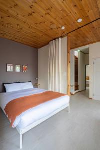 OgiYAMO-Kawana Ippekiko的一间卧室设有一张带木制天花板的大床