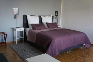 科隆科隆德兹会展中心酒店－朗盛竞技场的一间卧室配有一张大床,提供紫色床单和枕头