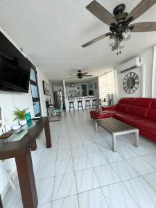 法哈多Casa Rosado @ Villa Marina Fajardo Pool Yunque的客厅配有红色的沙发和桌子