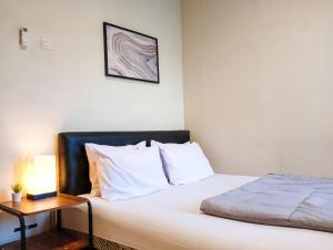 井里汶Sleep House 2BR Wifi Unlimited的一间卧室配有一张床和一张边桌