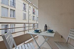尼姆L'Ecluse - Clim - Parking - Central的阳台配有桌椅和窗户