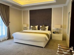 塔伊夫Remaj Hotel的一间卧室配有一张大床和大床头板