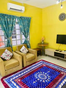 Kampong Alor GajahHomestay Zalida C Musleem的客厅配有两把椅子和地毯。