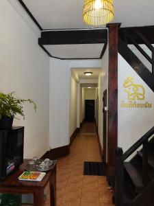 琅勃拉邦PHAI GUESTHOUSE的走廊,建筑里,有桌子和吊灯