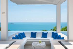 苏梅岛BLUE ELEPHANT Luxury Pool Villa Koh Samui by Blue Mountain Villas的客厅配有白色沙发和蓝色枕头。