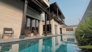 清迈Sareeviengping Hotel Chiangmai的一座房子,旁边设有游泳池