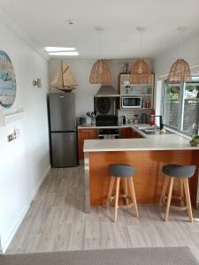 旺阿帕劳阿Adorable Beach Unit Stanmore Bay的厨房配有柜台和2张凳子
