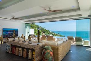苏梅岛BLUE ELEPHANT Luxury Pool Villa Koh Samui by Blue Mountain Villas的带沙发的客厅,享有海景