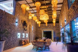 苏梅岛BLUE ELEPHANT Luxury Pool Villa Koh Samui by Blue Mountain Villas的用餐室配有桌椅和吊灯。