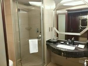 义乌义乌恒纳国际大酒店的一间带水槽和玻璃淋浴的浴室