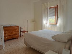 彼得拉桑塔Casa del Nonno的一间卧室配有一张床、一个梳妆台和一扇窗户。