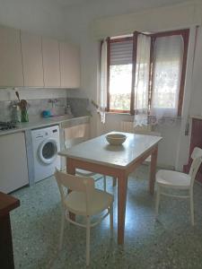 彼得拉桑塔Casa del Nonno的厨房配有桌椅和洗衣机。