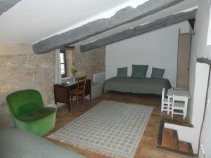 圣萨蒂南艾普特Le Jas des aiguiers的一间卧室配有一张床、一张桌子和一把绿色椅子