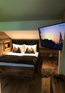 蓬高圣约翰Appartements Lehenhof的一间卧室配有一张床和一台平面电视