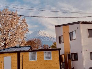 富士河口湖ヴィラ山間堂GrandVilla Mt Fuji view BBQ Bonfire AnnoVillas Sankando的一座房子后面的雪覆盖的山