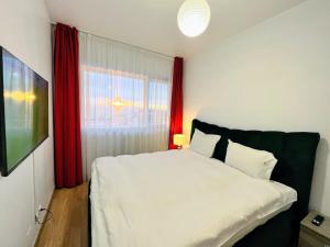 克卢日-纳波卡红屋酒店的卧室配有白色的床和红色窗帘