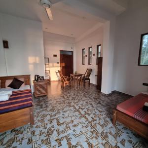 瓦都瓦Dhammika Beach Palace的客厅配有床和桌椅