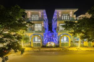 岑山Villa FLC Sầm Sơn BT VIP Phong Cách Địa Trung Hải的一座建筑,上面有蓝色的灯光
