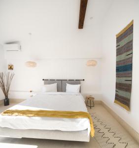 奥林普Hook Of Love - Le Mirage de la Mer的卧室配有白色的床,上面有黄色的毯子