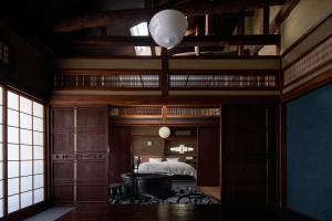 丰冈市城崎温泉 旅館 つばき乃 - Kinosaki Onsen Ryokan Tsubakino的一间卧室配有一张高架床和一张大床