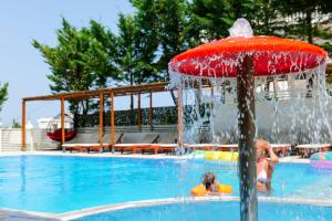 卡萨米尔6 Milje Hotel的儿童在带喷泉的游泳池玩耍
