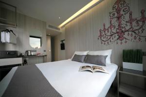 新加坡Hotel 81 Premier Princess的卧室配有白色的床,上面有两本书