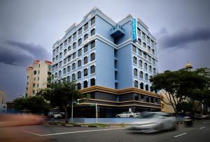 新加坡Hotel 81 Premier Princess的前面有一辆汽车,高大的蓝色建筑