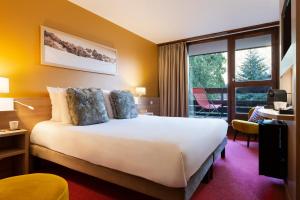 圣热尔韦莱班SOWELL HOTELS Mont Blanc et SPA的酒店客房设有一张床和一个大窗户