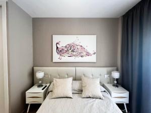 奥罗佩萨德尔马Tropical y Lujoso Complejo的一间卧室配有一张带两个床头柜和一幅画的床。