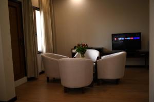 Bồ Sơn东都明月酒店Dong Do Minh Nguyet的配有桌椅和电视的客房