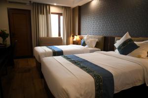 Bồ Sơn东都明月酒店Dong Do Minh Nguyet的酒店客房设有两张床和窗户。