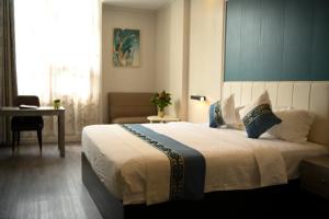 Bồ Sơn东都明月酒店Dong Do Minh Nguyet的一间卧室配有一张大床、一张桌子和一个窗户。