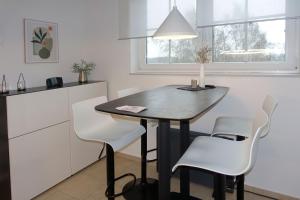 高尔维茨FIP Park Weitblick的一间带桌子和白色椅子的小厨房