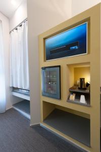 布林迪西行政精品酒店的酒店客房的墙上配有平面电视